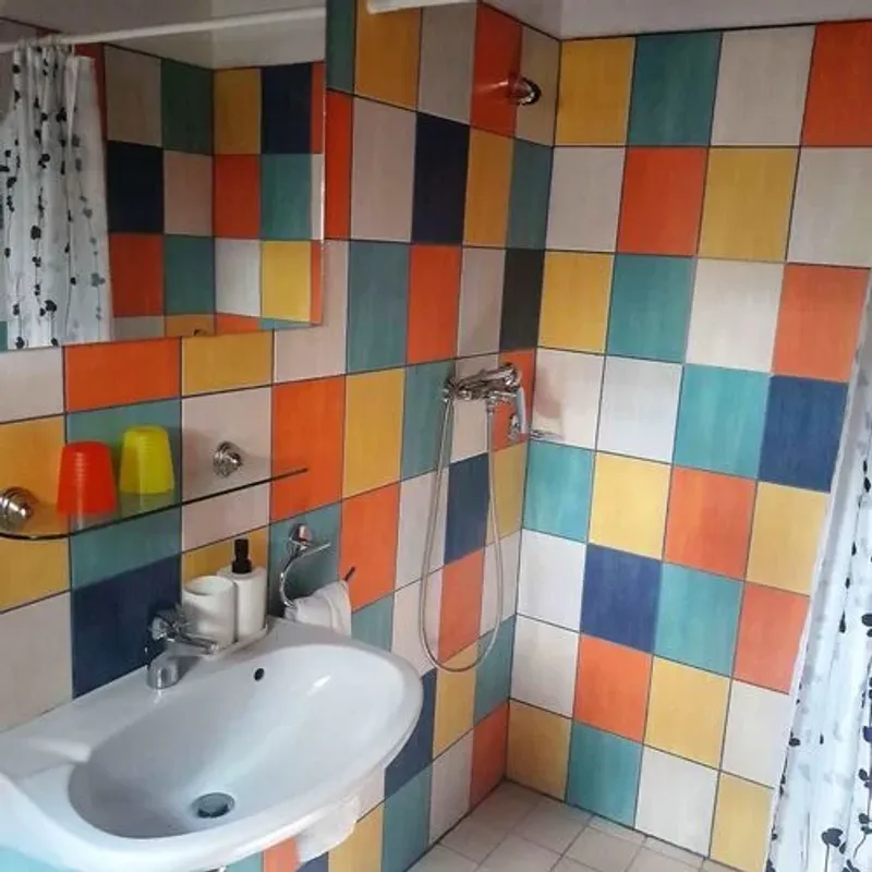 Tágas fürdőszoba zuhanyzóval és mosógéppel