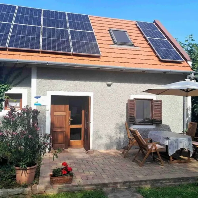 Barátságos homlokzatú családi ház nyári növényzettel