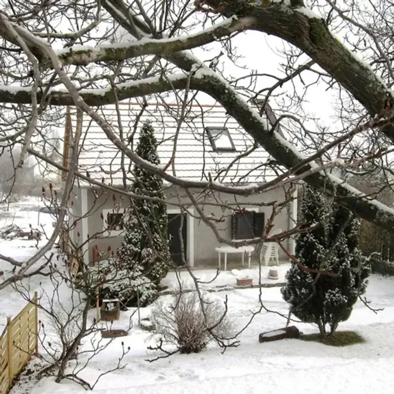 Havas téli táj, hófödte családi ház