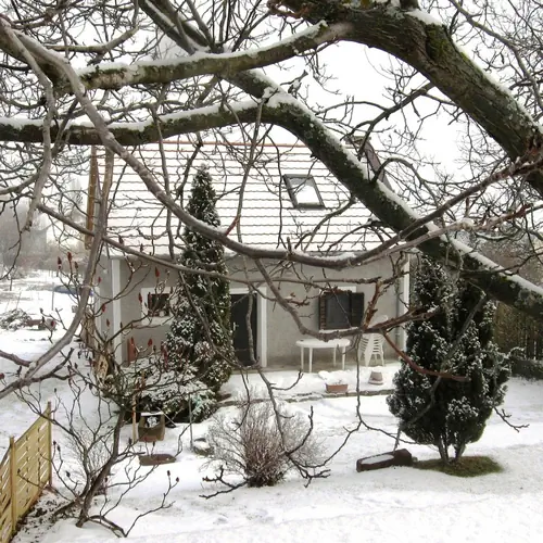 Havas téli táj, hófödte családi ház